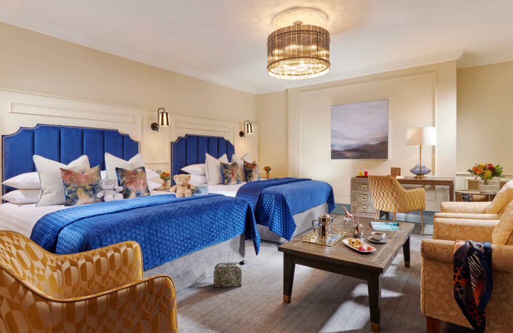 Large family guest room with two beds, lounge area and luxury furnishings at Ariel House Dublin