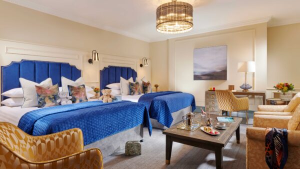 Large family guest room with two beds, lounge area and luxury furnishings at Ariel House Dublin
