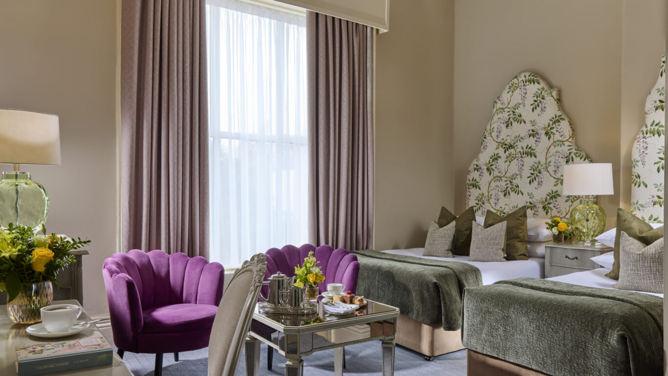 Chambre supérieure spacieuse avec lits jumeaux, têtes de lit fleuries et coin salon à l'Ariel House Dublin