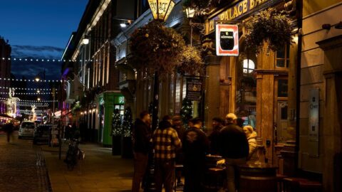 People outside The Palace Bar in Dublin at night enjoying nightlife near Ariel House
