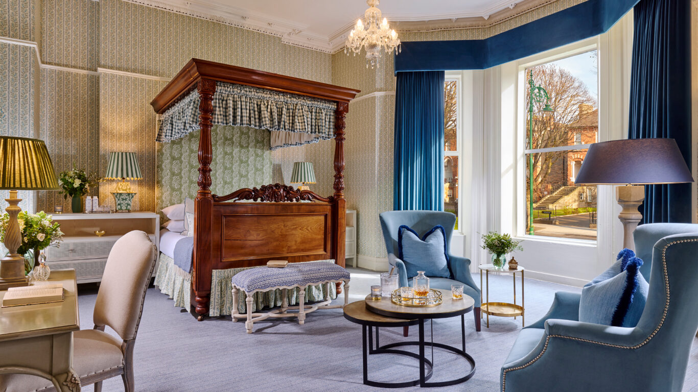 Luxurious junior suite at Ariel House Dublin with canopy bed, chandelier, and elegant seating area