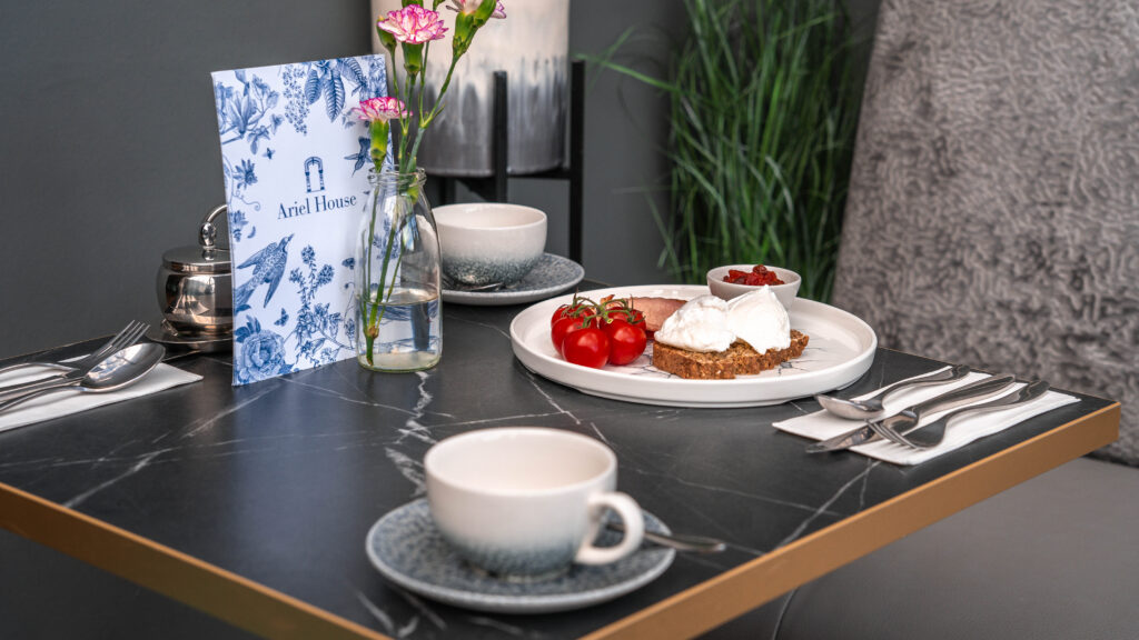 Breakfast table at Ariel House Dublin with poached eggs, tomatoes, coffee and guidebook