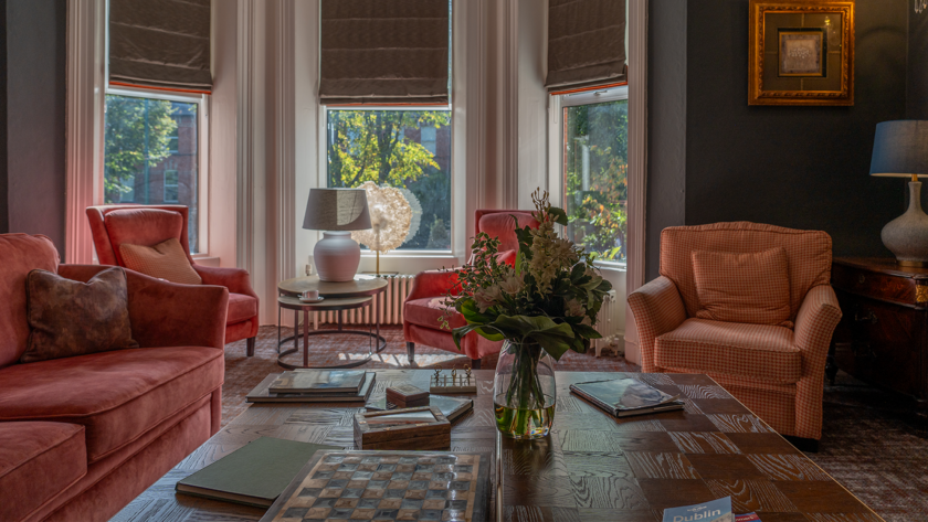 Coffee table close-up of Ariel Houses' Drawing Room, with fresh flowers, table games and Dublin guides.